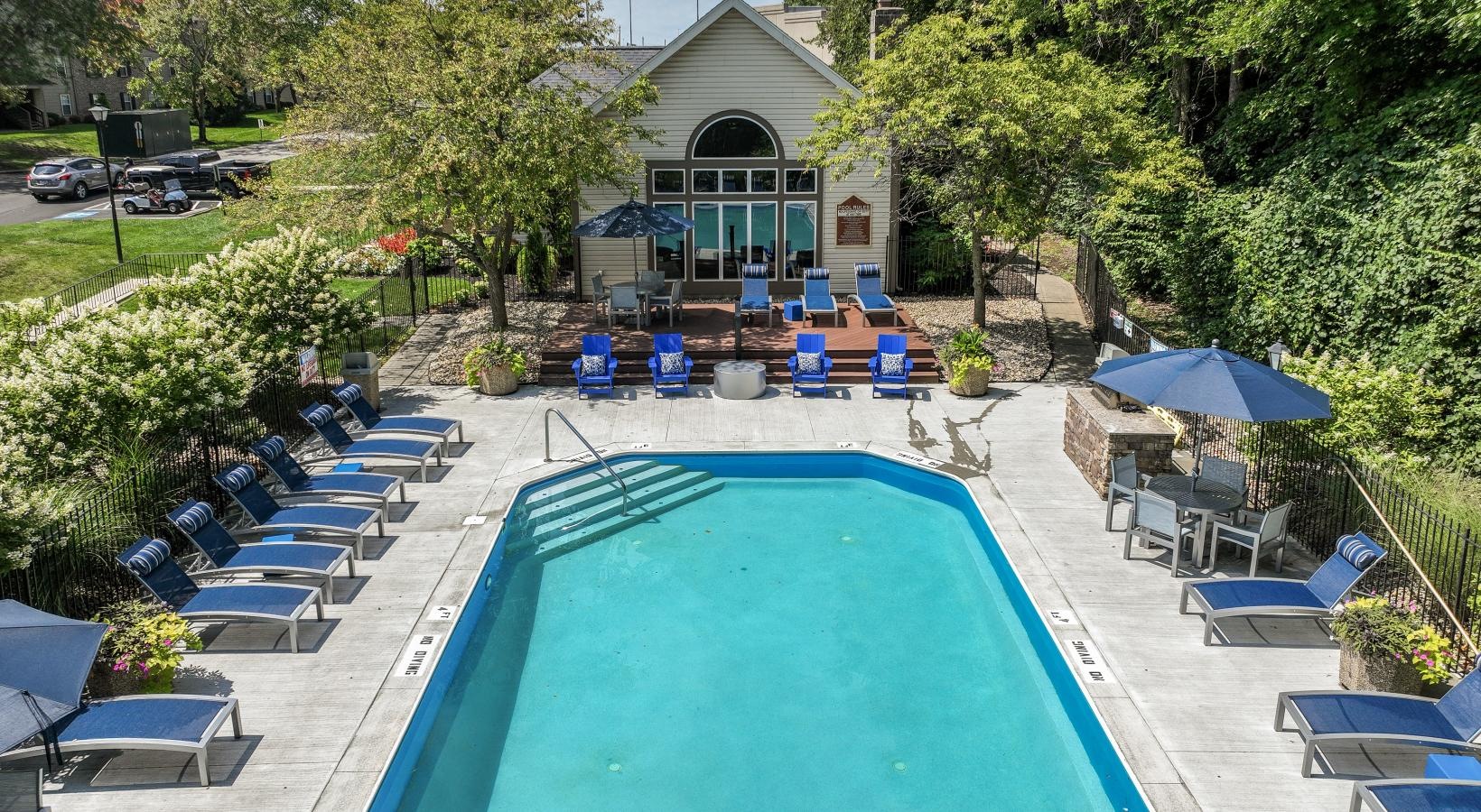 Relax and unwind poolside a pool with chairs around it