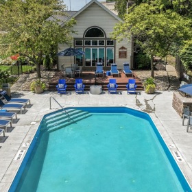 Relax and unwind poolside a pool with chairs around it