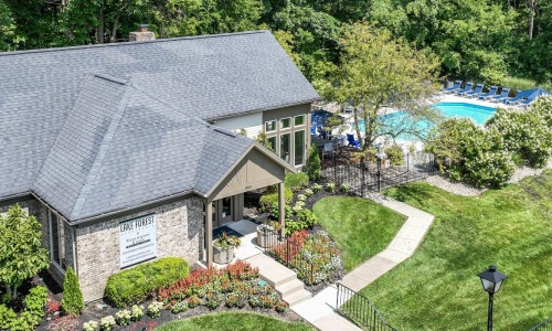 a house with a pool and trees around it