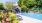 a swimming pool with a house in the background